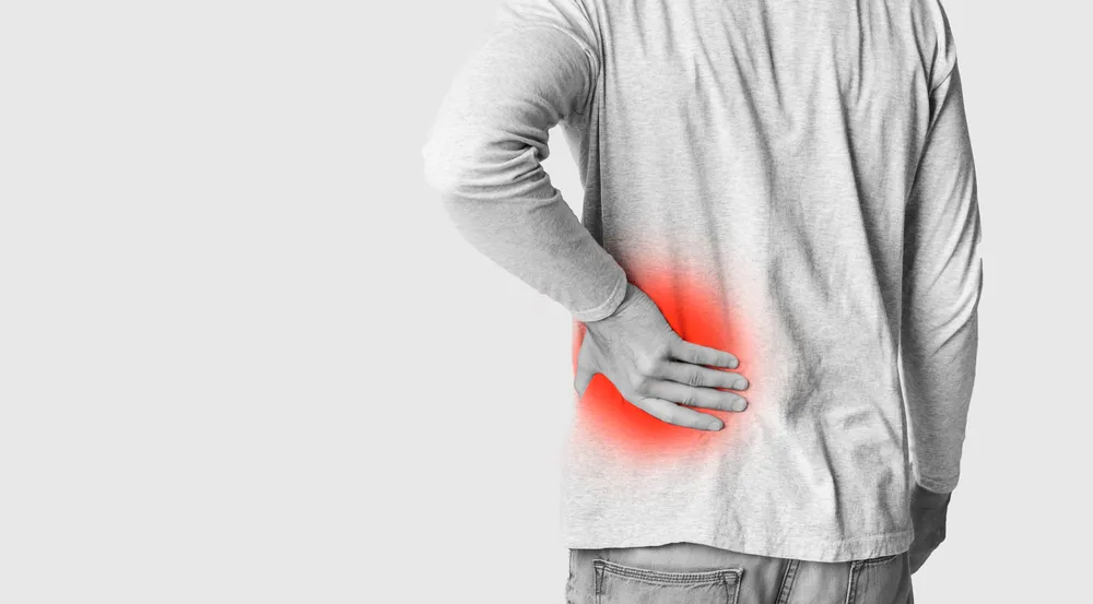 a man holding hip back with pain