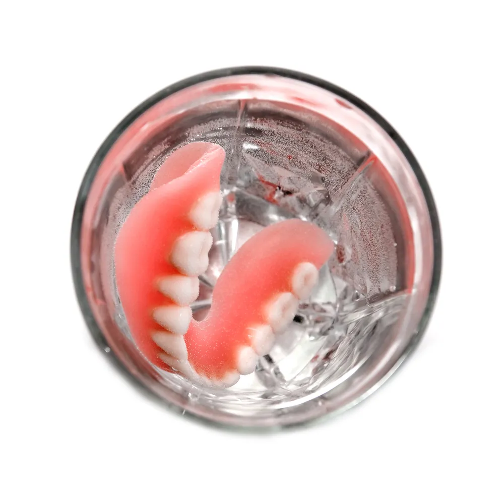 dentures soaking in glass of water
